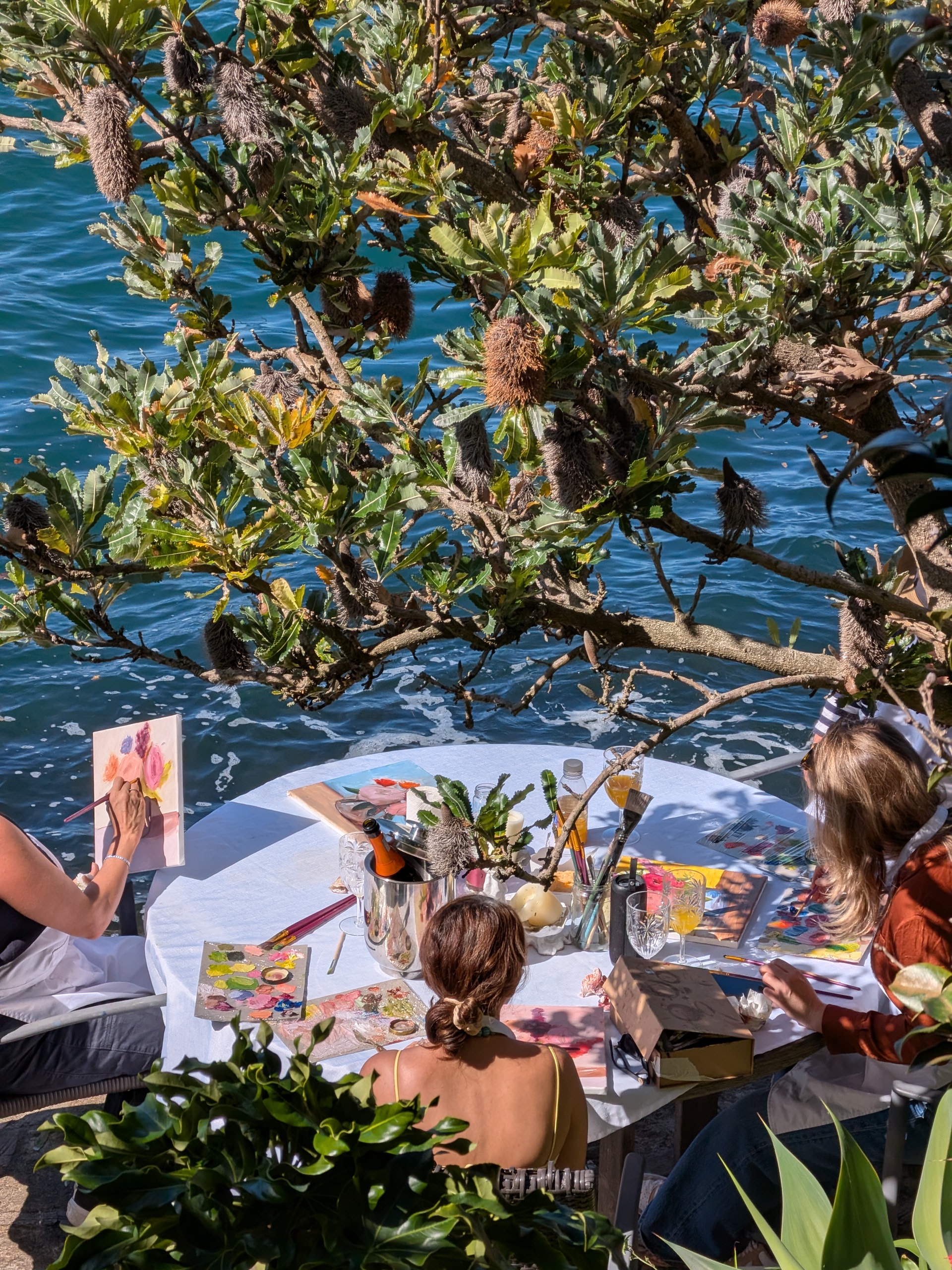 A laid high-tea table beside easels set for floral painting